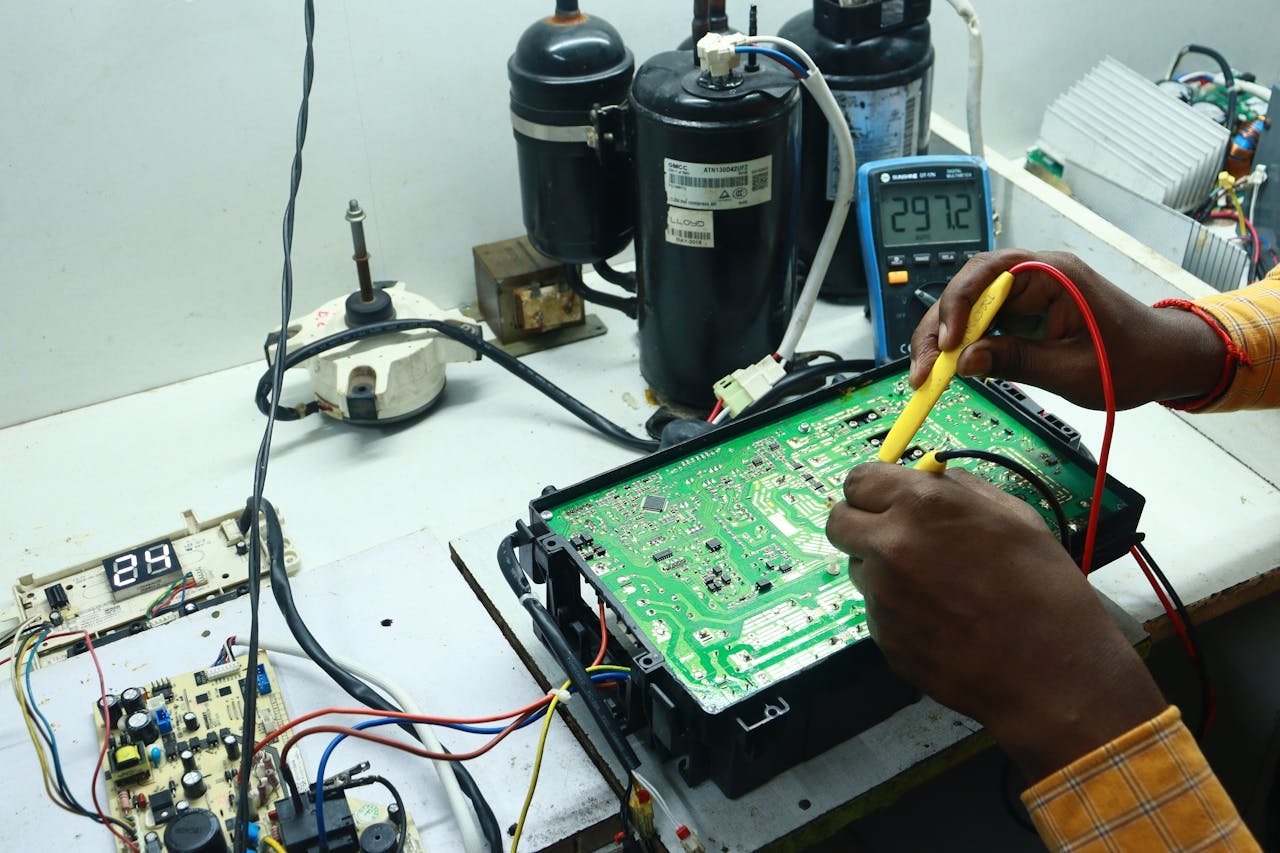 Technician working on AC PCB with tools and equipment, captured in New Delhi workshop.